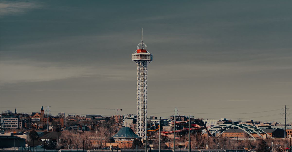 Dramatic view of a distinctive urban tower against a moody sky.