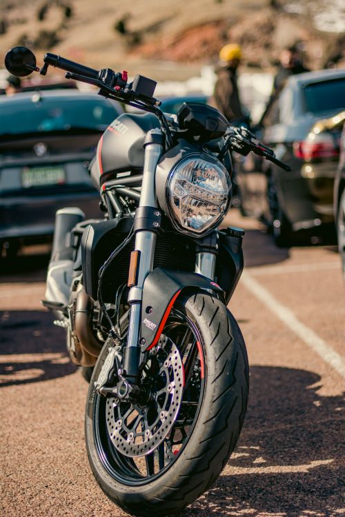 Free Close-up of a modern motorcycle parked outdoors in a sunny setting. Stock Photo