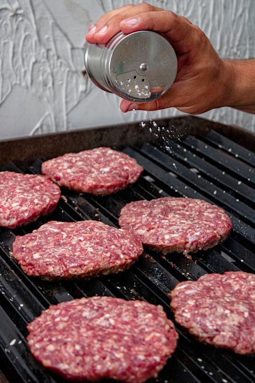 Hand Salting Meat on a Barbecue