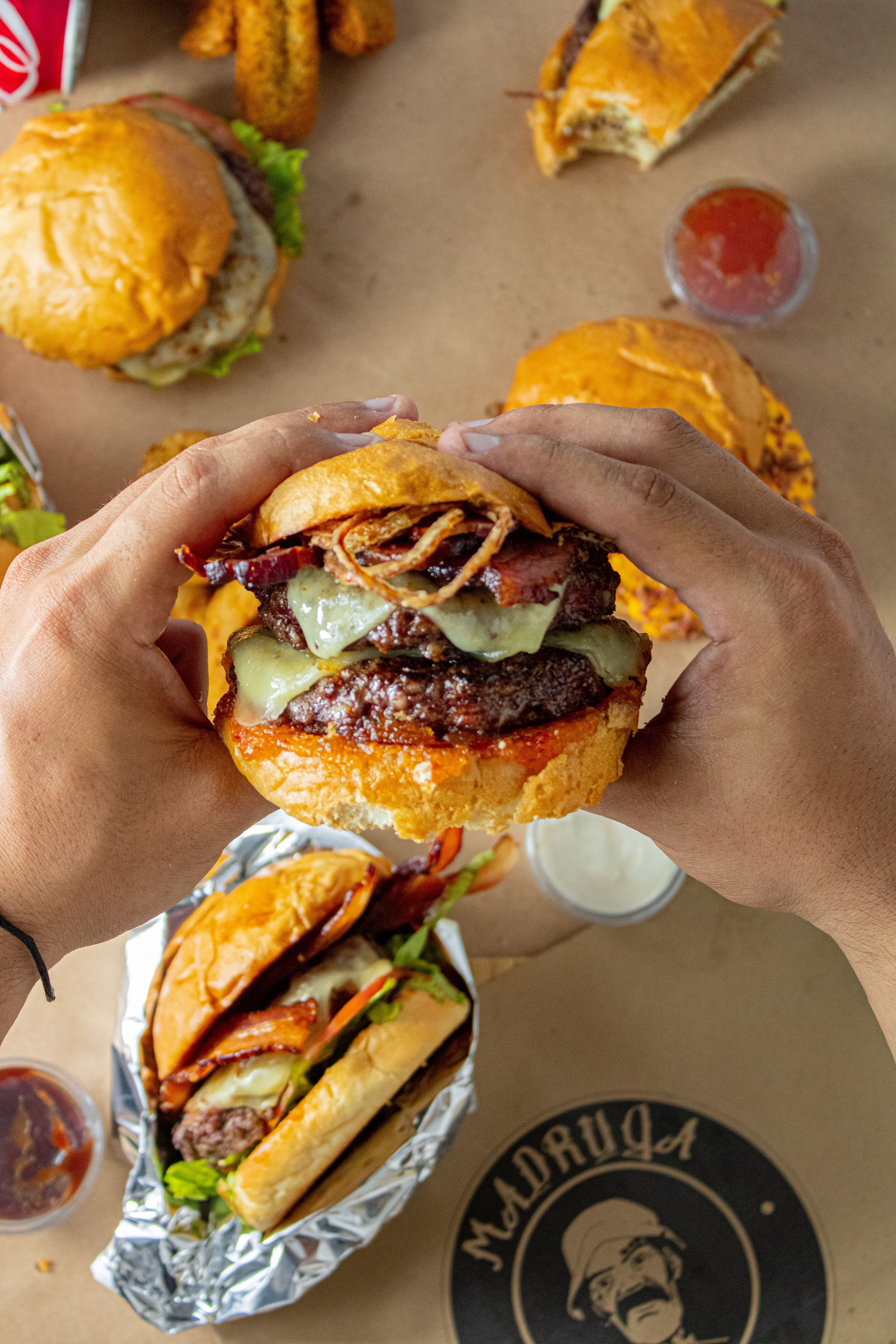A juicy burger with toppings held by hands, perfect for food enthusiasts.