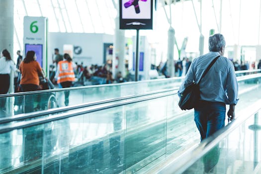 A bustling airport scene with travelers on a moving walkway in a modern terminal.