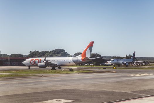 Airliners taxiing on a sunny day at an airport, ready for takeoff.