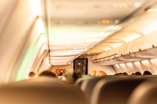 Free Interior of a commercial airplane with passengers blurred inside the cabin, showcasing travel atmosphere. Stock Photo