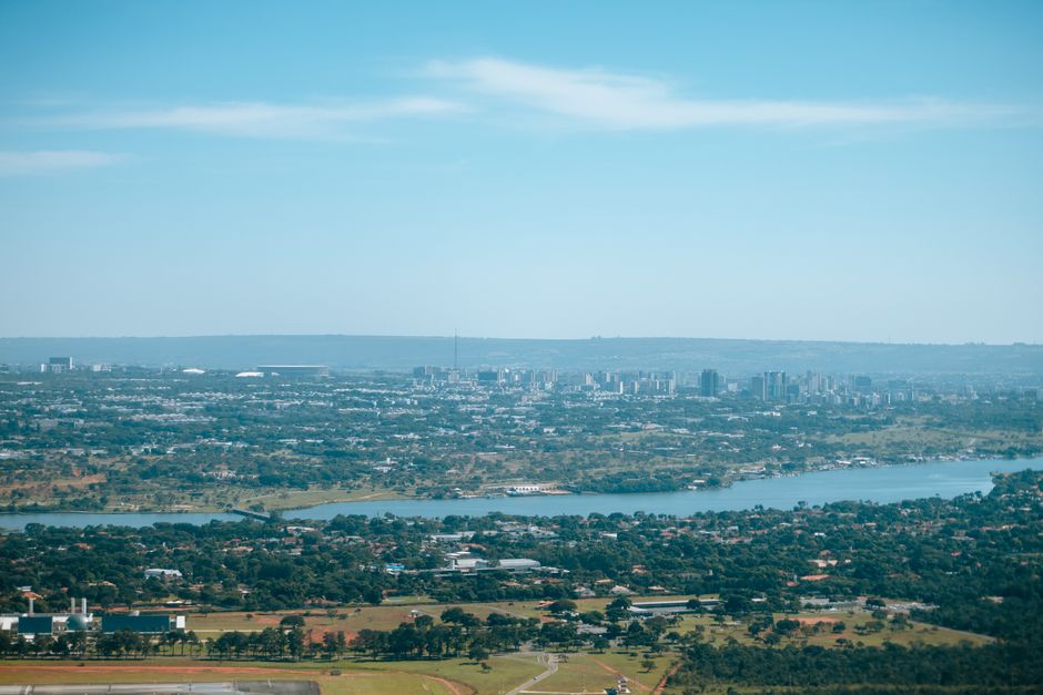 Aerial cityscape with skyline and river under clear blue sky.
