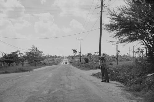 Man Standing on the Side of a Country Road 