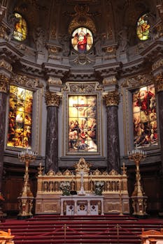 一座精致的教堂祭坛装饰着描绘宗教场景的金色和复杂彩色玻璃艺术品