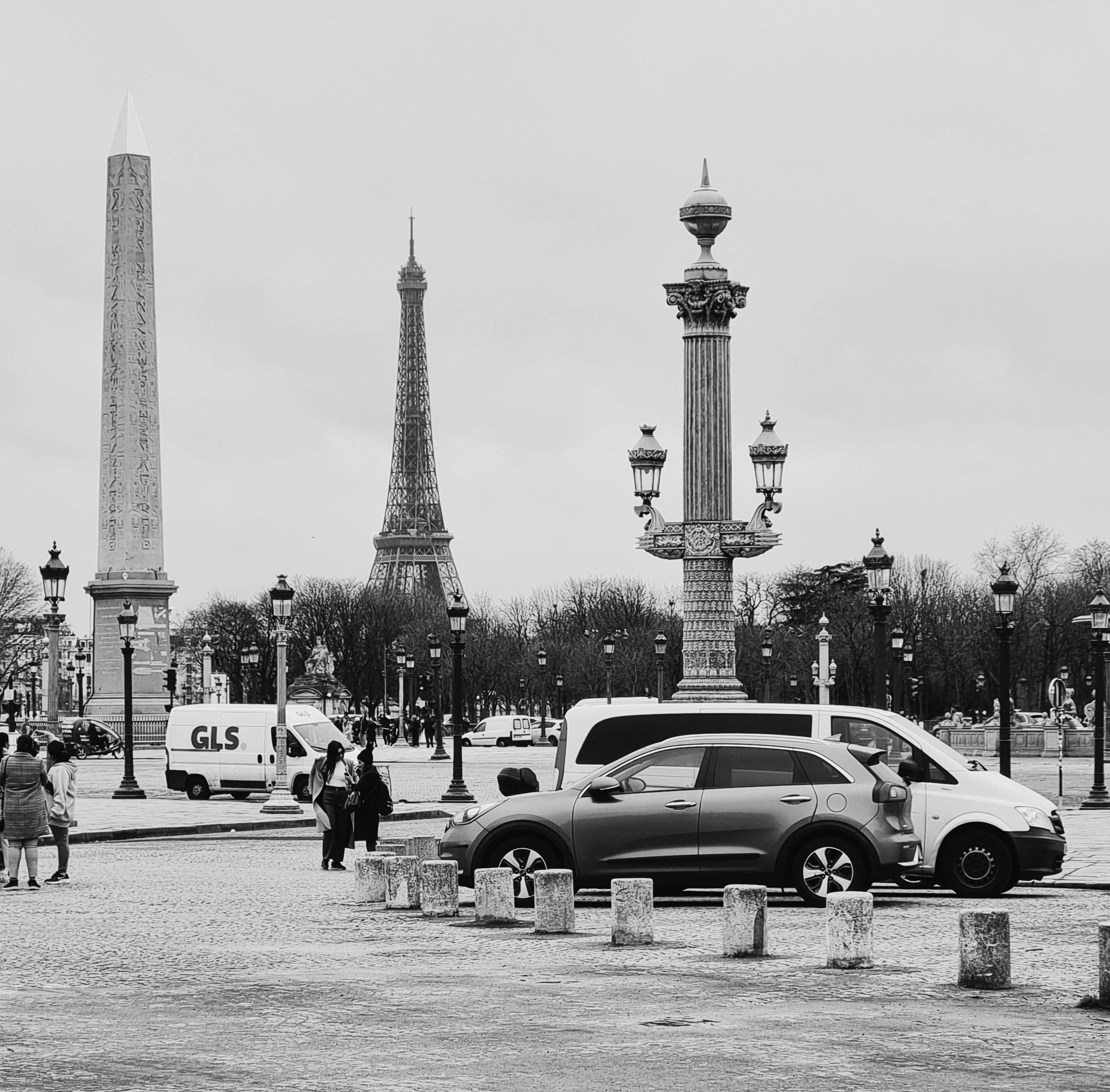 Classic black and white view of Paris street featuring the Eiffel Tower and iconic city elements.