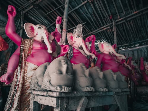 Pink Ganesha Figures and Grey Masks in a Storage Room