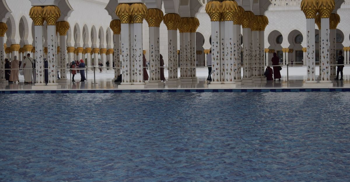 Serene view of the inner courtyard with reflections at Sheikh Zayed Grand Mosque, Abu Dhabi.
