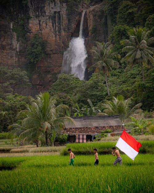 Kids Walking Through the Field with the Indonesian Flag