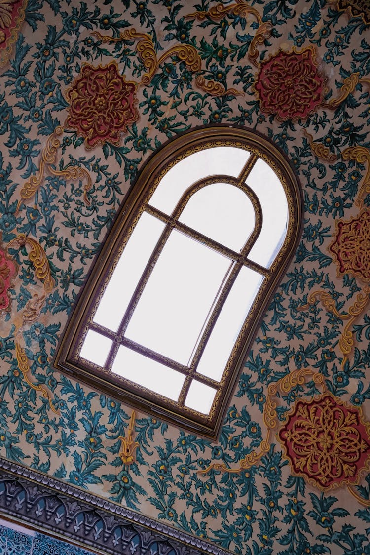 Window On A Wall Covered In Floral Wallpaper