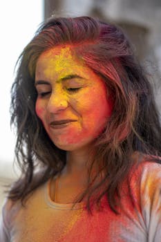 A joyful woman immersed in the colors of Holi, celebrating Indian culture with vibrant hues.