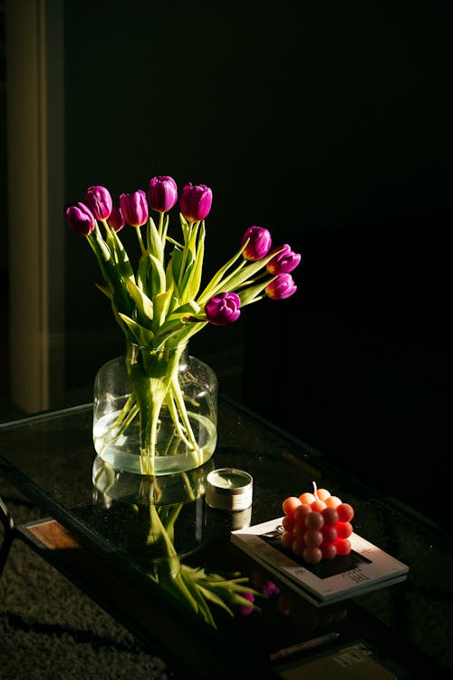 Bouquet of Purple Tulips in a Glass Vase and a Candle 