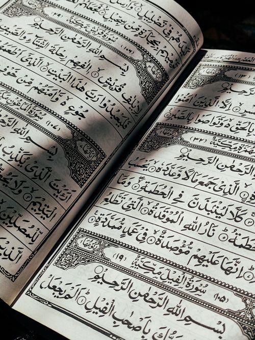 Free An open Quran with Arabic script, close-up view highlighting religious text. Stock Photo