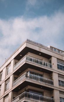 A contemporary residential building with balconies under a cloudy sky in Madrid, Spain.