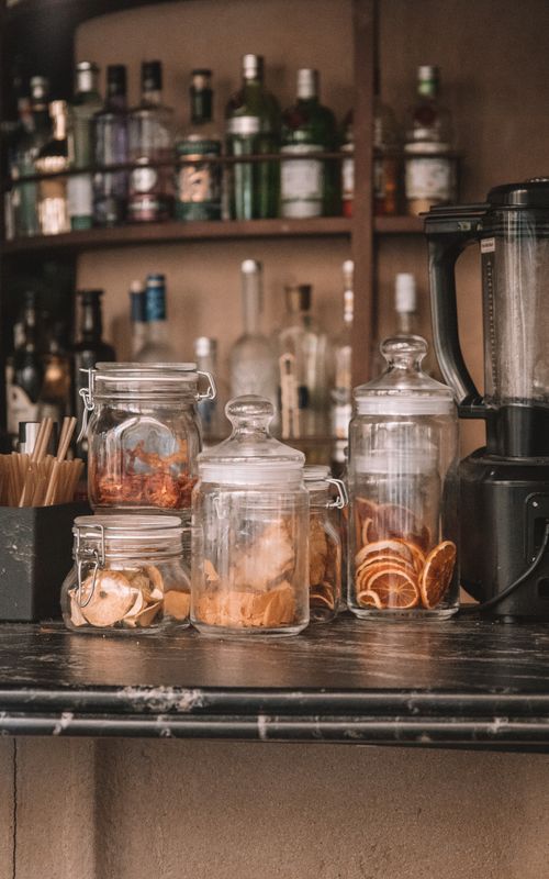 Free Rustic bar counter in Madrid featuring jars of dried fruits and a variety of bottles. Stock Photo