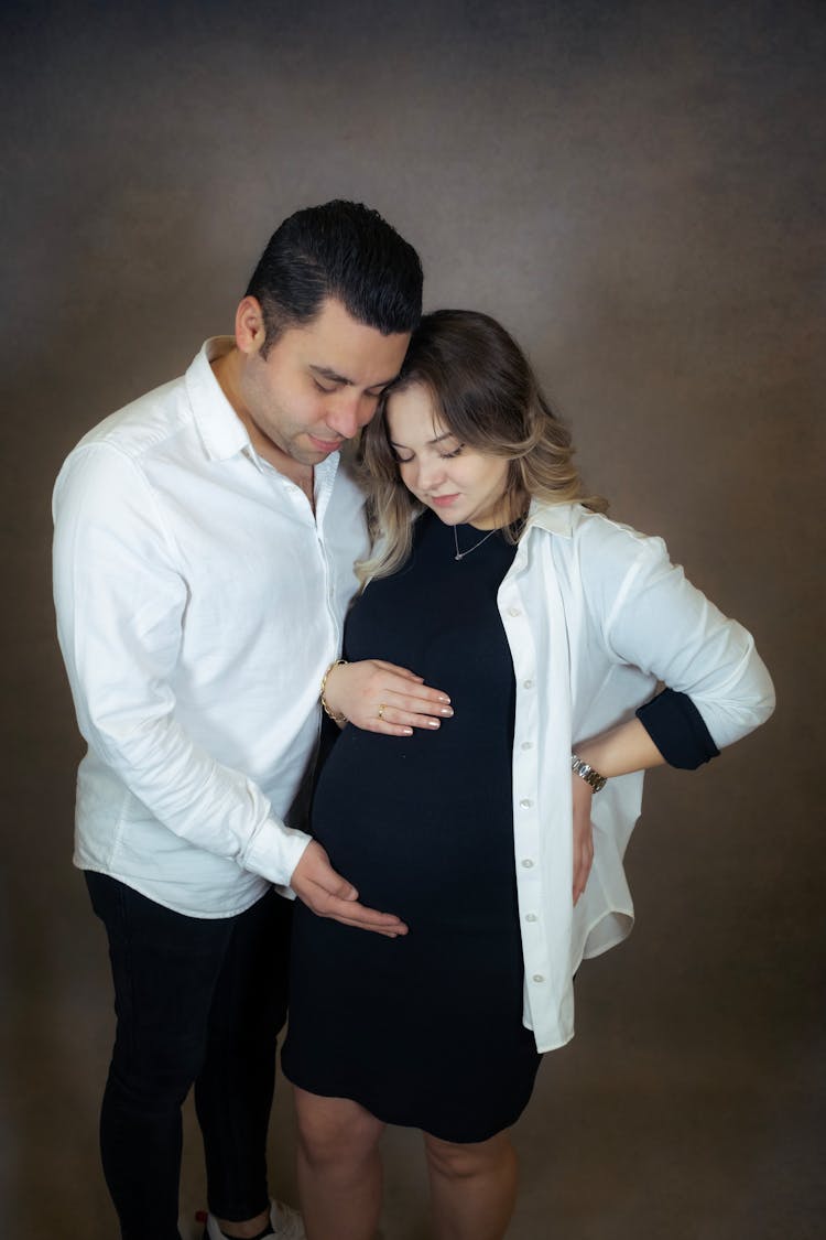 Husband With His Hand On The Belly Of His Pregnant Wife 