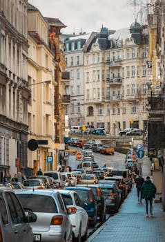 Vibrant European street scene with classic buildings, bustling traffic, and pedestrians.