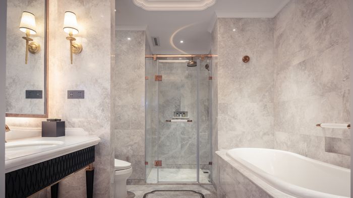 Marble bathroom with glass shower and gold fixtures