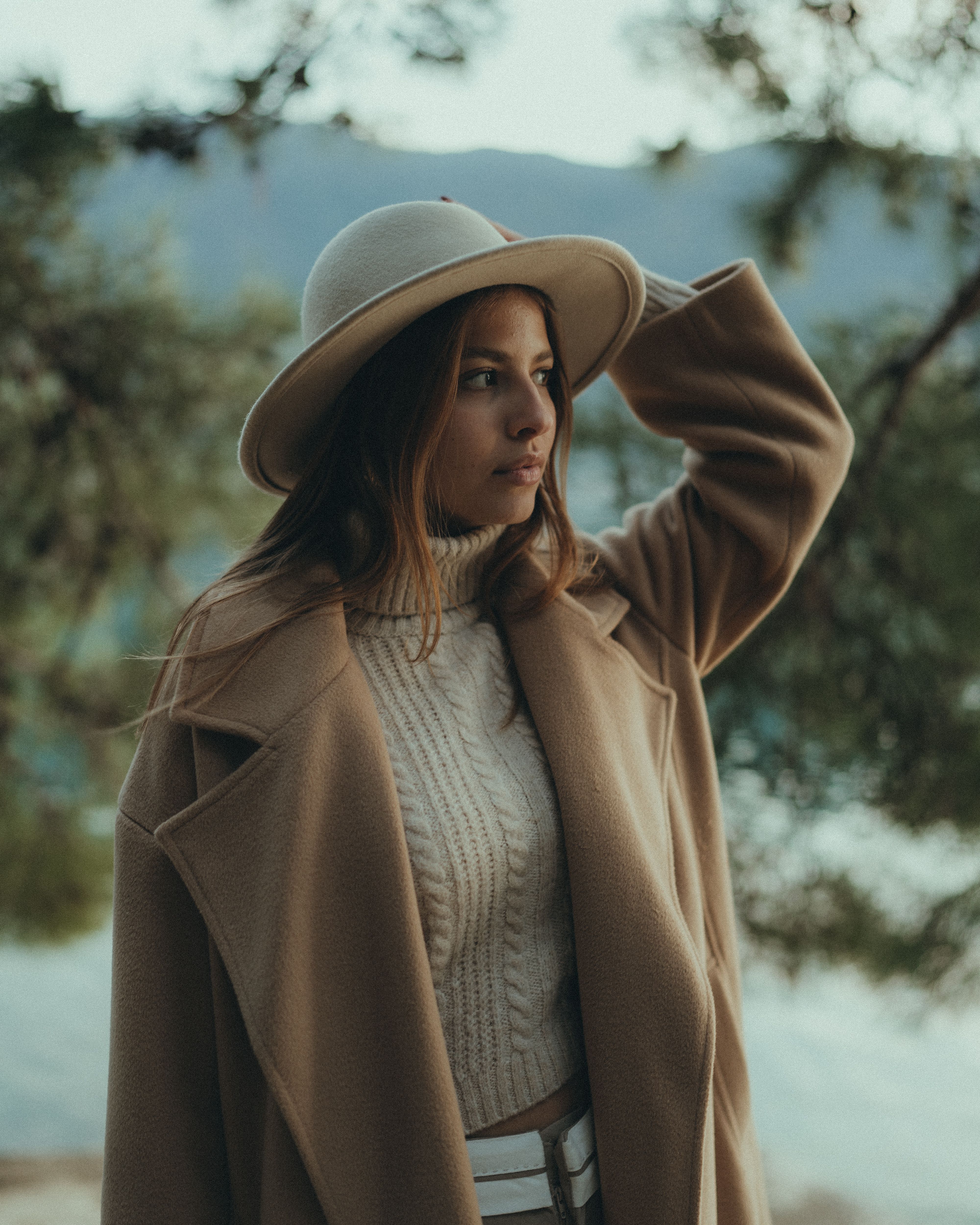 Woman in distressed jeans and camel sweater