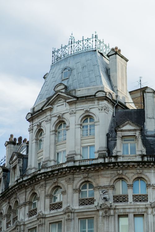 Free Close-up of an ornate baroque architectural building facade with detailed rooftop and windows. Stock Photo