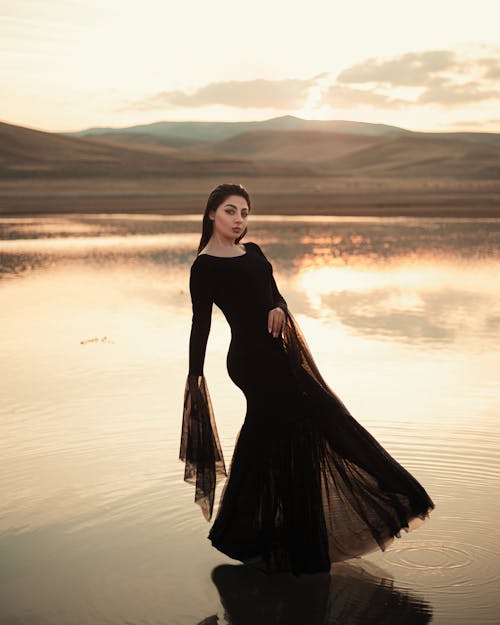 Woman in Dress Posing in Water on Sunset