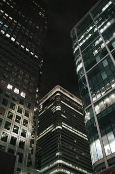 A striking view of illuminated skyscrapers against a night sky, capturing urban architecture.