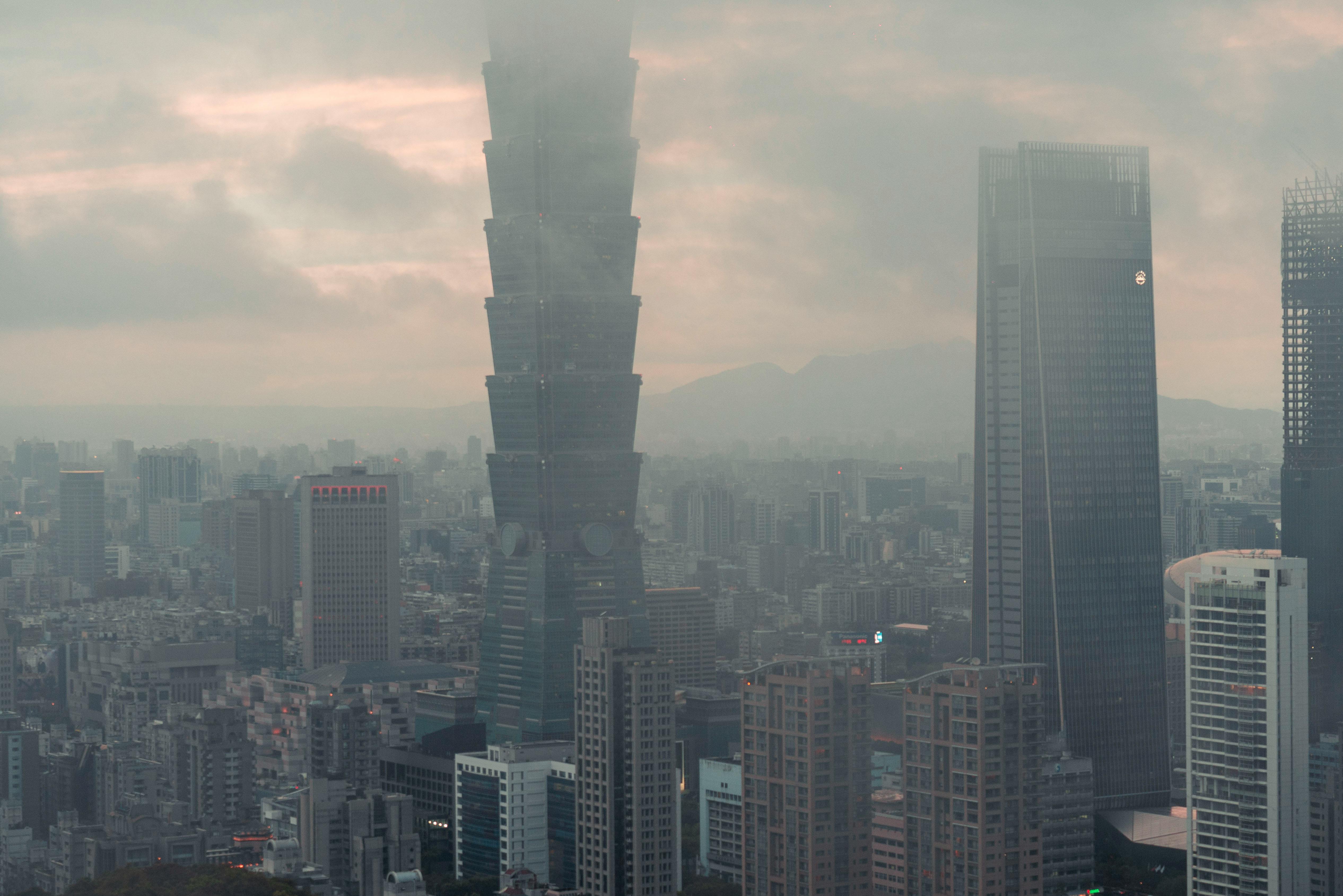 A moody aerial view of Taipei with the iconic Taipei 101 peeking through the fog during the day.