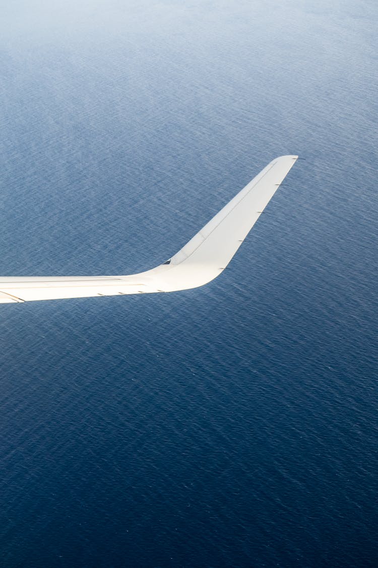 Wing Of Airplane Flying Over Sea