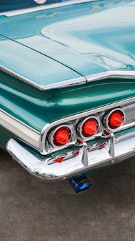 Close-up of a classic car tail fin with chrome details and red tail lights.