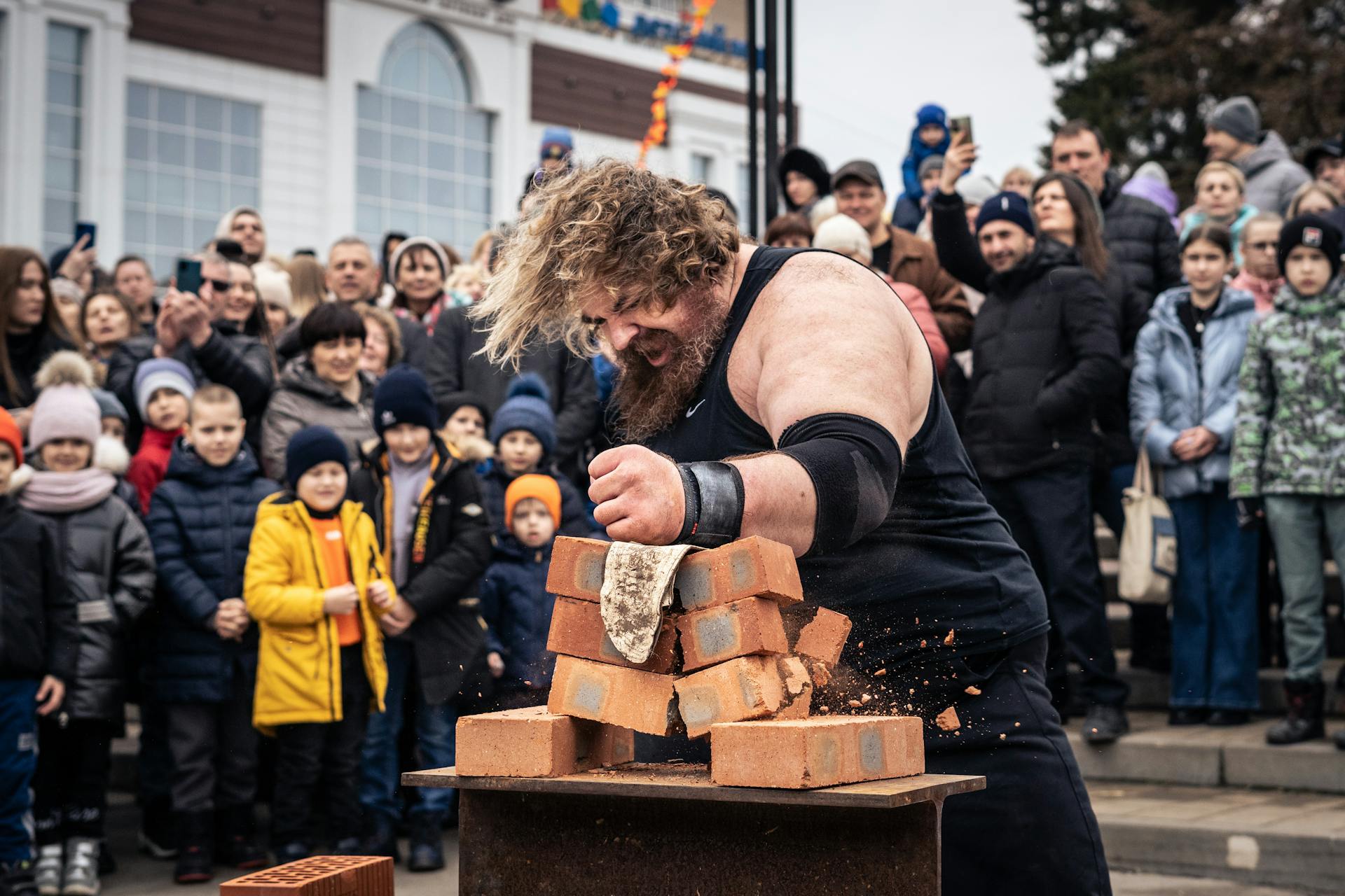 Crowd Watching a Man Break Bricks with His Arm