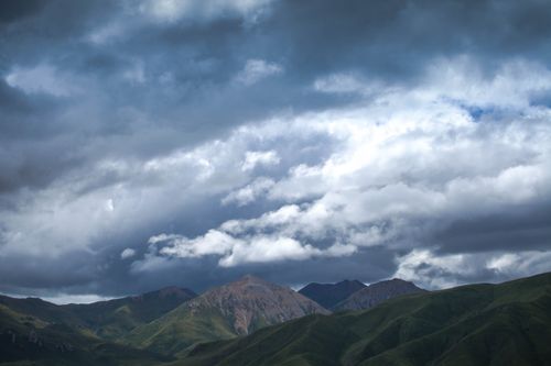 Free Capture of a mountainous landscape under a dramatic cloudy sky. Stock Photo