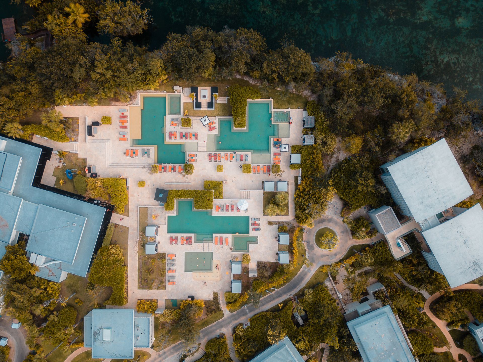 Aerial shot of resort swimming pools surrounded by lush greenery in Playa del Carmen.