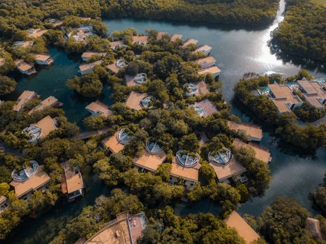 Aerial view of lush tropical resort houses surrounded by water in Playa del Carmen, Mexico.