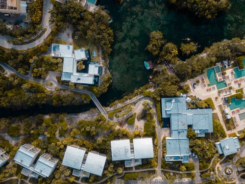 Free Aerial shot of a vibrant resort area in Playa del Carmen, showcasing lush greenery and modern architecture. Stock Photo
