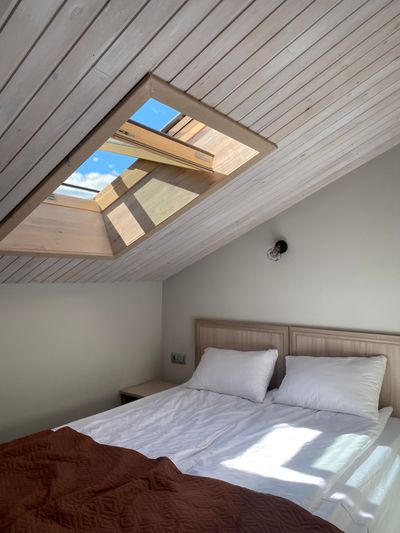 Attic room with a made bed, photo by Anna Androshuk on Pexels