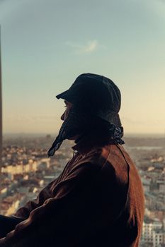 Silhouette of a stylish man in a cityscape, showcasing urban fashion at sunset.