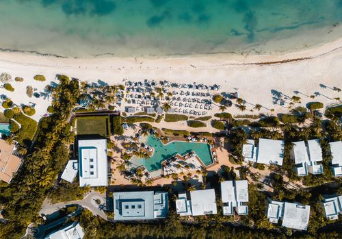 Free Stunning aerial view of Playa del Carmen with beach umbrellas and a resort pool in Mexico. Stock Photo