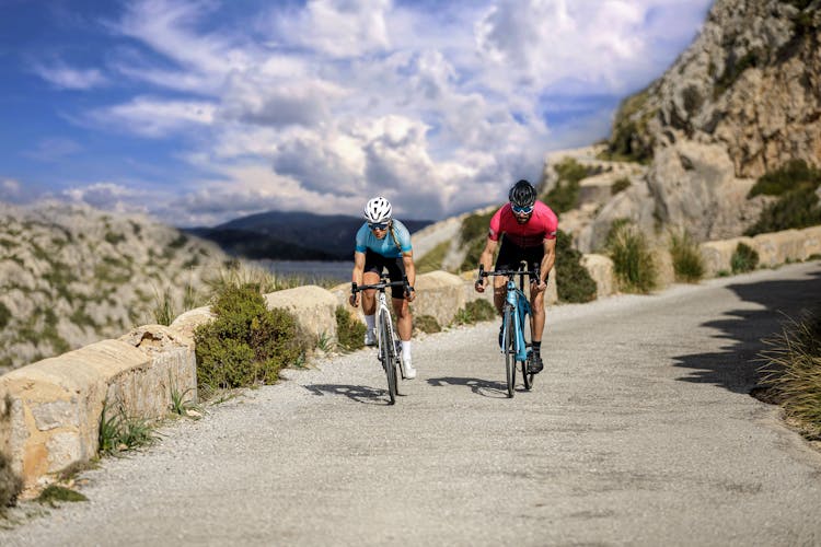 Men Riding On Bicycles On A Scenic Road