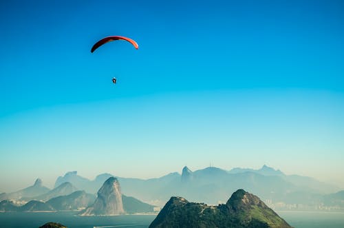 Gratuit Photo Panoramique D'une Personne Parachutisme Au Dessus Du Lac Volcano Pendant La Journée Photos