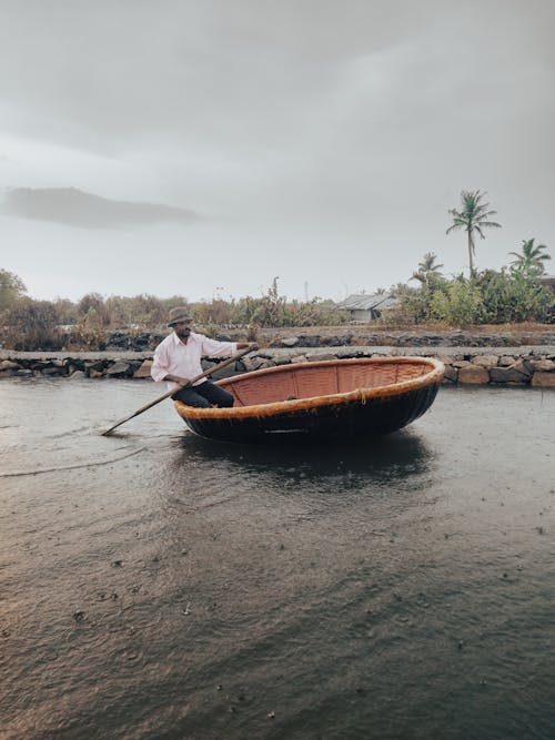 Man Sailing in Rowboat near Seashore