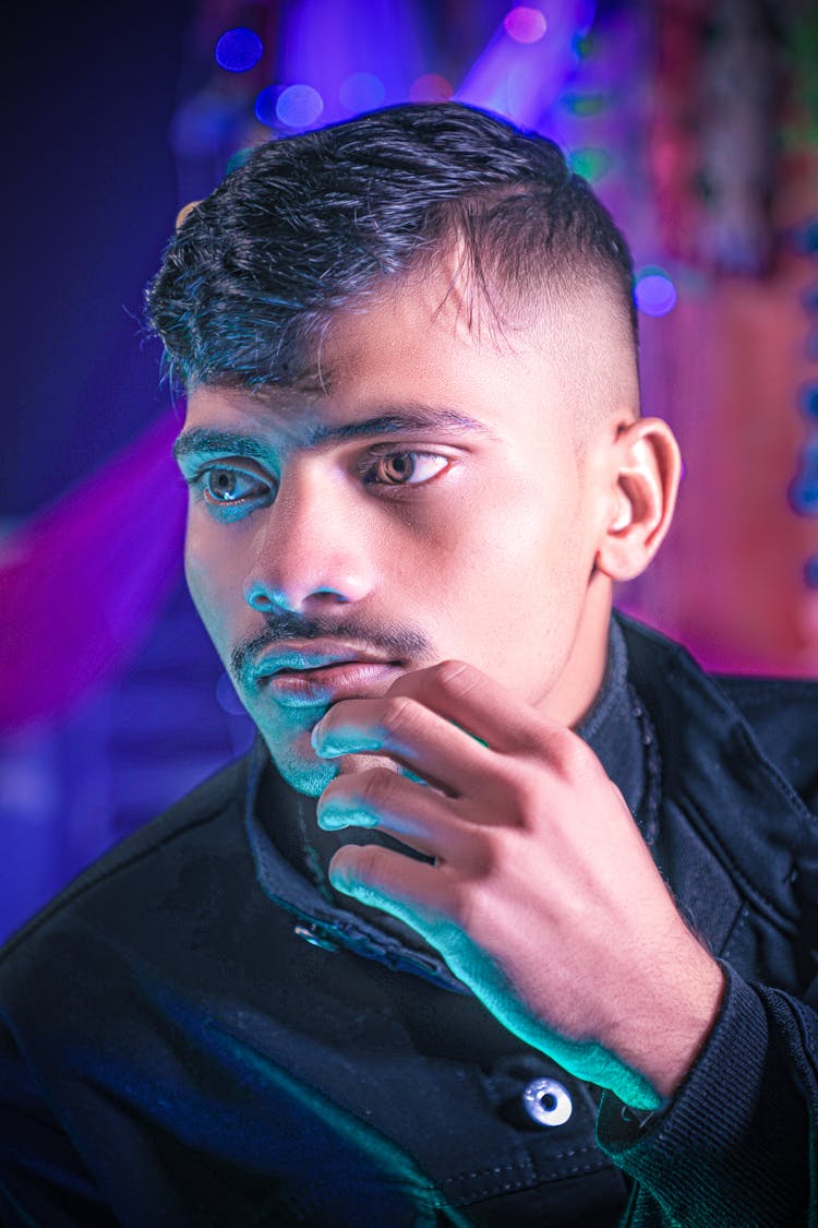 Portrait Of A Young Man On The Background Of Purple Lights