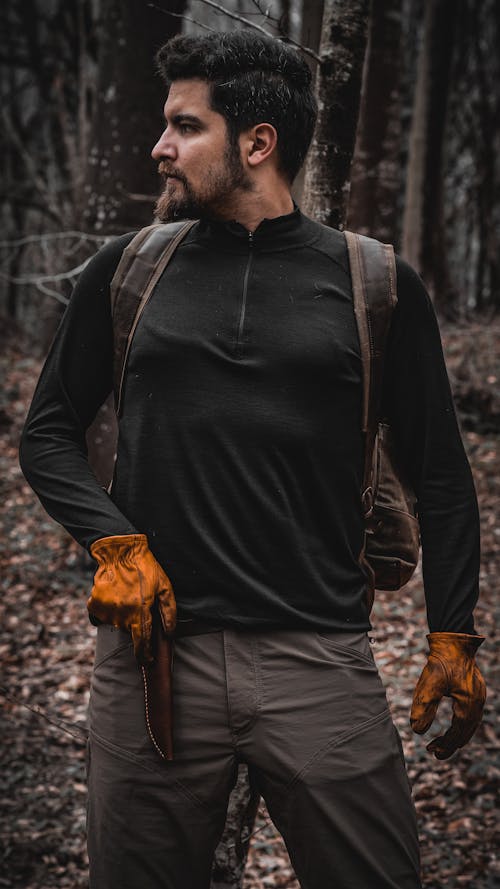 Man with a Knife in Leather Sheath on His Belt in the Forest