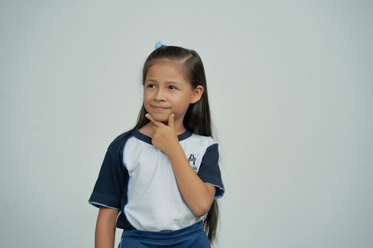 Smiling Girl Standing Near Wall Thinking