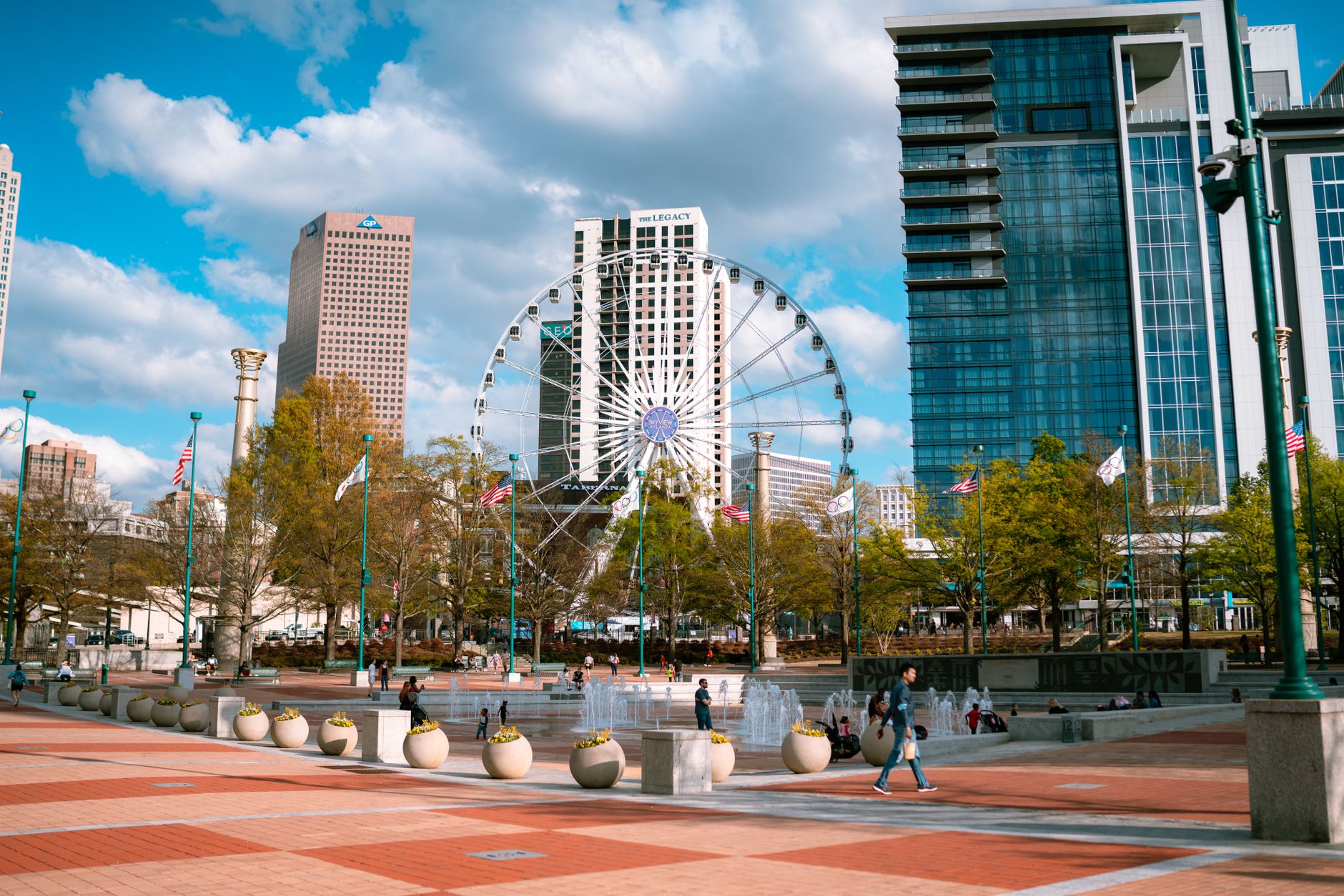 Day view of Centennial Olympic Park with skyscrapers and Ferris wheel in Atlanta, Georgia.