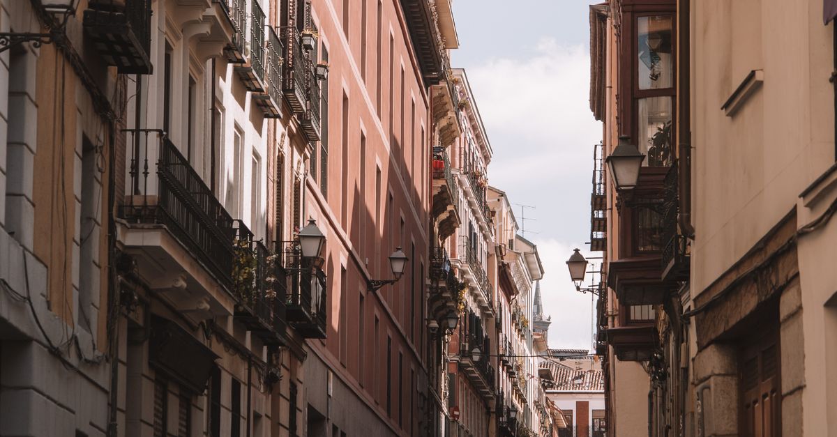 Discover a picturesque narrow street in Madrid, Spain, lined with historic buildings and classic architecture.