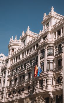Classic architectural facade along Madrid's Gran Vía under a clear blue sky.