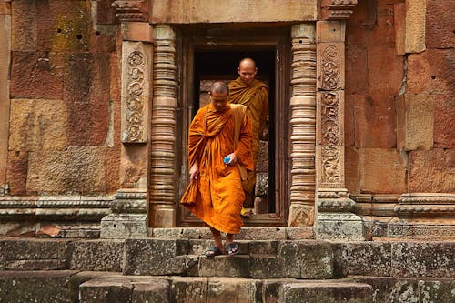 콘크리트 계단을 걸어가는 주황색 가운을 입은 두 스님