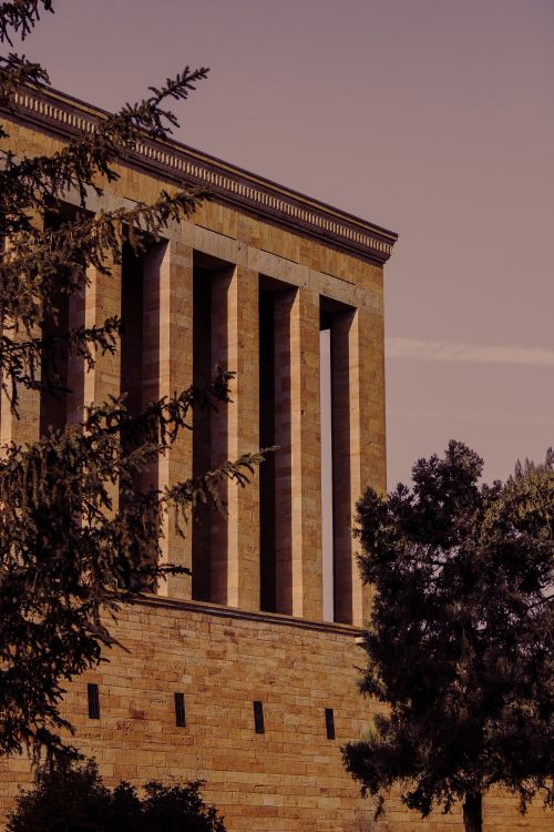 Free Anıtkabir surrounded by trees under a striking pink sky in Türkiye. Stock Photo