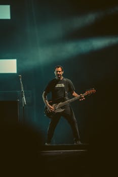 Energetic male guitarist performing live on stage at a music festival.